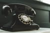 black rotary telephone on white surface